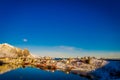 Henningsvaer, Norway - April 09, 2018: Beautiful above view of wooden buildings with huge mountaing behind in