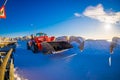 HENNINGSVAER, NORWAY - APRIL 10, 2018: Outdoor view of red tractor covered with snow on a sunny day during wniter in a