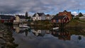 HenningsvÃÂ¦r, AustvÃÂ¥gÃÂ¸ya, Lofoten, Norway - 08-29-2020: Traditional wooden houses and red colored rorbu with docking boat. Royalty Free Stock Photo