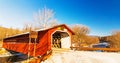 Vermont covered bridge and Winter ice and snow river Royalty Free Stock Photo