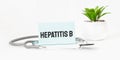 HEPATITS word on notebook,stethoscope and green plant Royalty Free Stock Photo