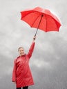 Her attitude shines through the rain. A beautiful young woman standing outside with her red umbrella. Royalty Free Stock Photo