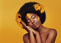 Her beauty is as delicate as a flower. Studio shot of a beautiful young woman posing topless with sunflowers in her hair Royalty Free Stock Photo