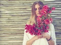Her beauty just keeps blooming and blooming. an attractive young woman holding a bunch of fresh flowers.