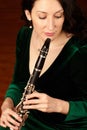 Her breath gives birth to beauty. A beautiful clarinetist sitting and playing her instrument.