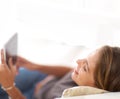 Her digital tablet is always close at hand. a young woman using her laptop at home. Royalty Free Stock Photo