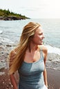 She is in her element. a cheerful young woman standing on a beach while looking out at the ocean outside during the day. Royalty Free Stock Photo