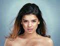 Her eyes speak a thousand words. Studio shot of a stunning young woman posing against a blue background.