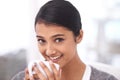 Her favorite time of day. A beautiful young woman enjoying a cup of coffee in her living room. Royalty Free Stock Photo