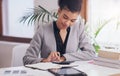 Her finances are looking good. an attractive young businesswoman using a calculator and a notebook while working on her Royalty Free Stock Photo