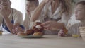 Mother and her four teen son eating pies and drinking orange juice in the kitcken standing at the table close up