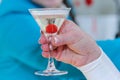 In her hand a glass of champagne with a cherry inside. Royalty Free Stock Photo