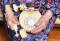 In her hands an old 90-year-old grandmother holds in her hand a white old landline phone, poverty and poverty, the hunger of the o