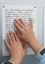 Her hands reading Braille table
