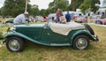 Her husband lending her a hand to clear the barriers so that she can drive her Vintage MG Motor car at Glamis Castle.