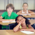 Her minds in another place entirely. A little girl daydreaming during a school lesson. Royalty Free Stock Photo