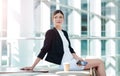 Her minds always racing with thoughts. an attractive young businesswoman looking thoughtful while using a smartphone in Royalty Free Stock Photo