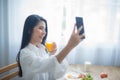 With her phone in hand the beautiful asian woman couldn't resist taking a selfie while enjoying her healthy and delicious Royalty Free Stock Photo