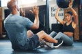 Her trainer knows how to challenge her. a sporty young woman exercising with a medicine ball with the help of her