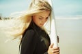 On her way into the ocean. A young surfer girl holding her surfboard.