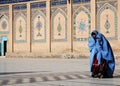 Two women in burqas in front of the Great Mosque of Herat in Afghanistan