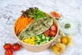 HERB MINT BAKED DORY with carrot, cucumber, tomato, corn and mint raita served in a bowl isolated on grey background side view Royalty Free Stock Photo