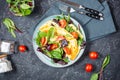 Herb omelette with cheese, cherry tomatoes and arugula on black stone background. Breakfast