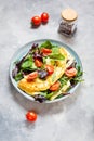 Herb omelette with cheese, cherry tomatoes and arugula on concrete background.