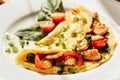 Herb omelette with chives, cherry tomatoes and spinach on wooden table under sunlight. Healthy breakfast concept