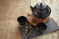 Herbal asian tea on vintage wooden table. Top side view of teapot and cups on black rock with copy space Royalty Free Stock Photo