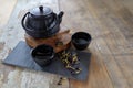 Herbal asian tea on vintage wooden table. Top side view of teapot and cups on black rock with copy space Royalty Free Stock Photo