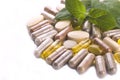 Herbal capsules and herbal leaves Royalty Free Stock Photo