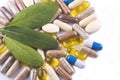 Herbal capsules and herbal leaves Royalty Free Stock Photo