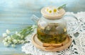 Herbal chamomile tea and chamomile flowers near teapot and tea glass. Rural or countryside background Royalty Free Stock Photo