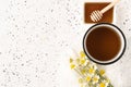 Herbal chamomile tea in white cup and honey on white cement background Royalty Free Stock Photo