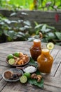 Herbal drinks of beras kencur and kunyit asam are packed in glass bottles serving with raw materials Royalty Free Stock Photo