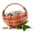 Herbal drug capsules in wicker basket. Alternative medicine concept.