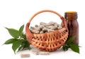Herbal drug capsules in wicker basket. Alternative medicine concept.