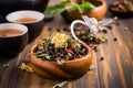 Herbal and fruit tea concept with teapot and infuser and assorted herbal leaves Royalty Free Stock Photo