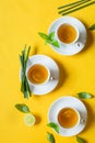 Herbal green tea with lemongrass in glass cup with fresh limes. Top view of three white cups of Lemon Grass Drink on a Yellow