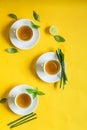Herbal green tea with lemongrass in glass cup with fresh limes. Top view of three white cups of Lemon Grass Drink on a Yellow Royalty Free Stock Photo