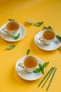 Herbal green tea with lemongrass in glass cup with fresh limes. Top view of three white cups of Lemon Grass Drink on a Yellow