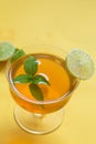 Herbal green tea with lemongrass in glass cup with fresh limes. Top view of two cups of Lemon Grass Drink on a Yellow Background