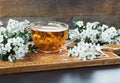 Herbal haw thorn tea from flower buds around blooming branches on wooden cutting board Royalty Free Stock Photo