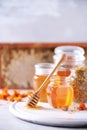 Herbal honey in jar with dipper, honeycomb, bee pollen granules, calendula flowers on grey background Royalty Free Stock Photo