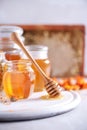 Herbal honey in jar with dipper, honeycomb, bee pollen granules, calendula flowers on grey background. Royalty Free Stock Photo