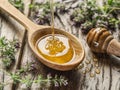 Herbal honey pouring into the wooden spoon. Spoon is on old wood Royalty Free Stock Photo