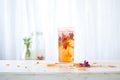 herbal iced tea with floating hibiscus petals, soft light