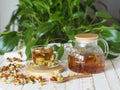 Herbal medicinal tea made from dried flowers of calendula and marigolds on a wooden table and with green leaves in the background. Royalty Free Stock Photo