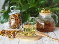 Herbal medicinal tea made from dried flowers of calendula and marigolds on a wooden table and with green leaves in the background. Royalty Free Stock Photo